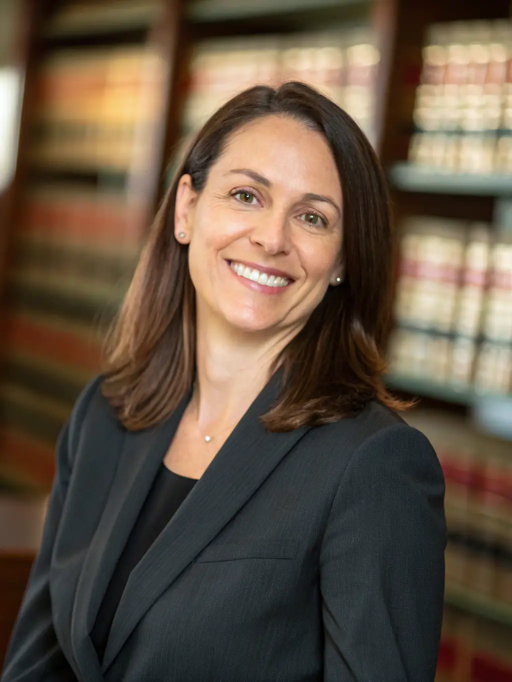 A professional headshot of a confident lawyer, smiling warmly, symbolizing improved client trust and stronger professional relationships.